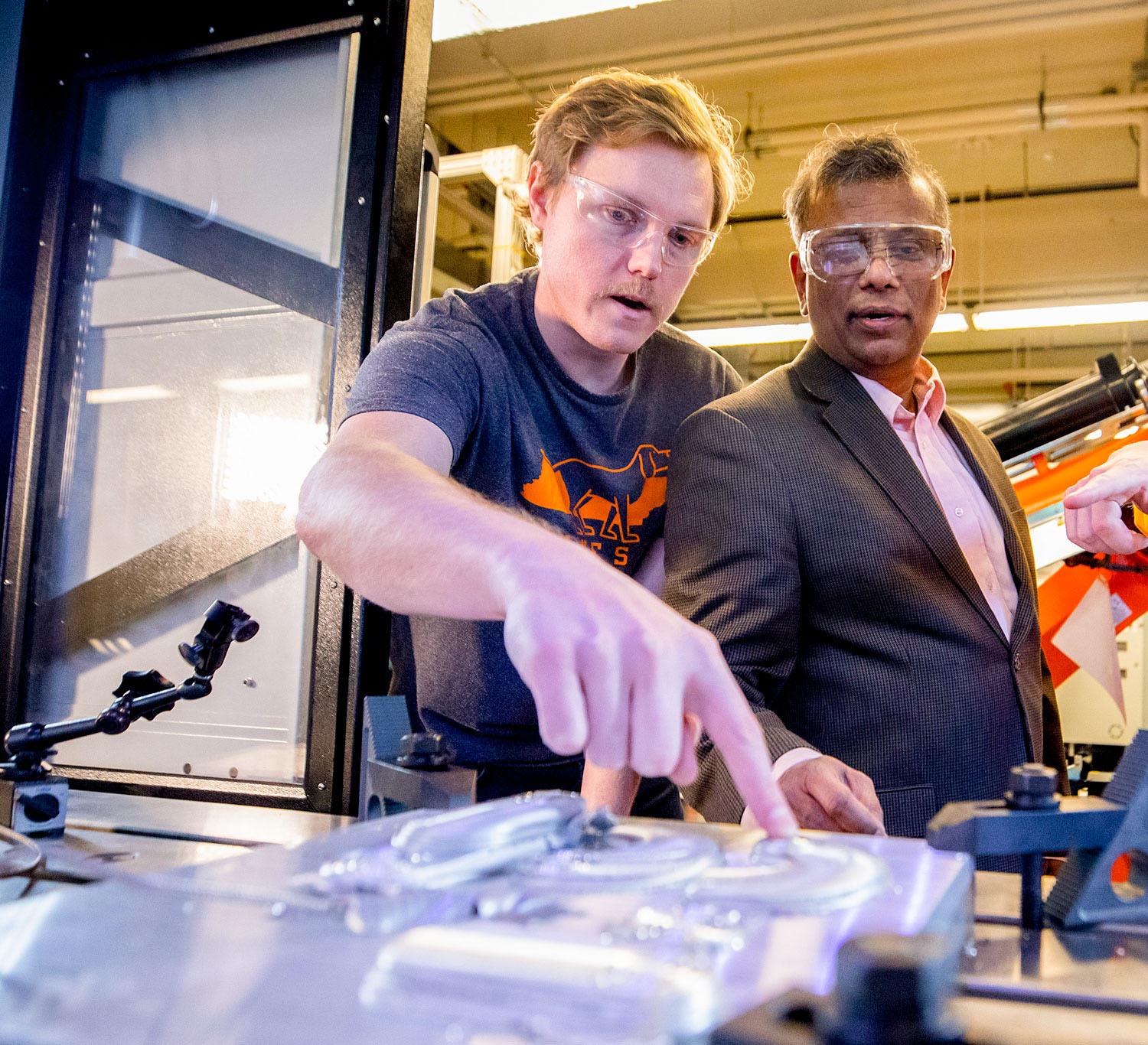 A professor works with students on the MELD Machine inside the Machine Tool Research Center in the Dougherty Engineering Building.