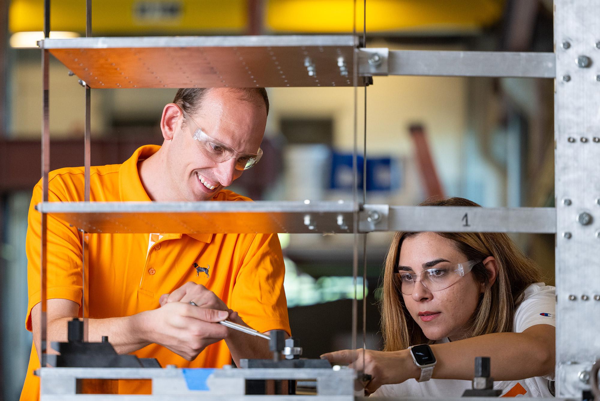 A professor and student install a structure on a 6 degrees-of-freedom shake table, which simulates an earthquake.